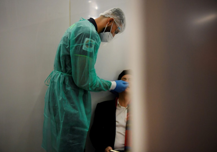 A health workers gives a Covid test to a recent arrival into Paris from China