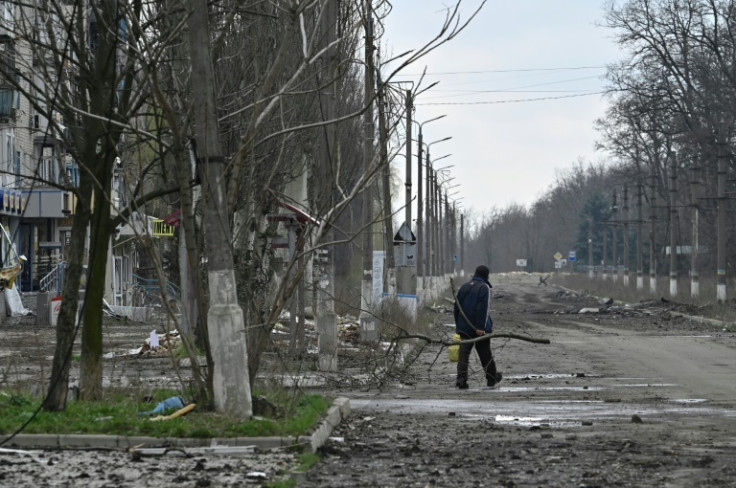 A resident carries a tree branch for firewood in the frontline town of Avdiivka