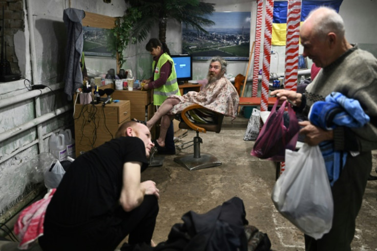 Resident Sergiy (C), waits for a haircut in a shelter run by volunteers in Avdiivka