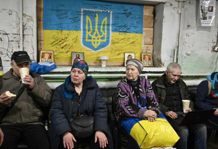 Kateryna (second from left) sits in a shelter run by volunteers in Avdiivka
