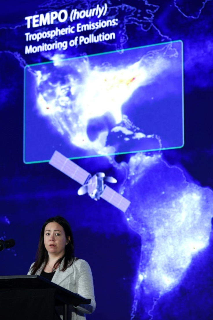 Laura Judd, an associate program manager at NASA, stands in front of a graphic that shows TEMPO's coverage zone over North America