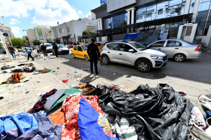 Migrant tents and belongings are scattered after the police operation