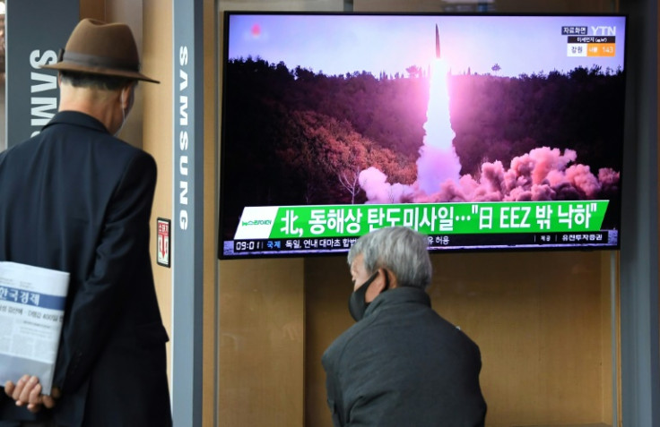 People in Seoul watch file footage of a North Korean missile test after Pyongyang launched a ballistic missile Thursday morning