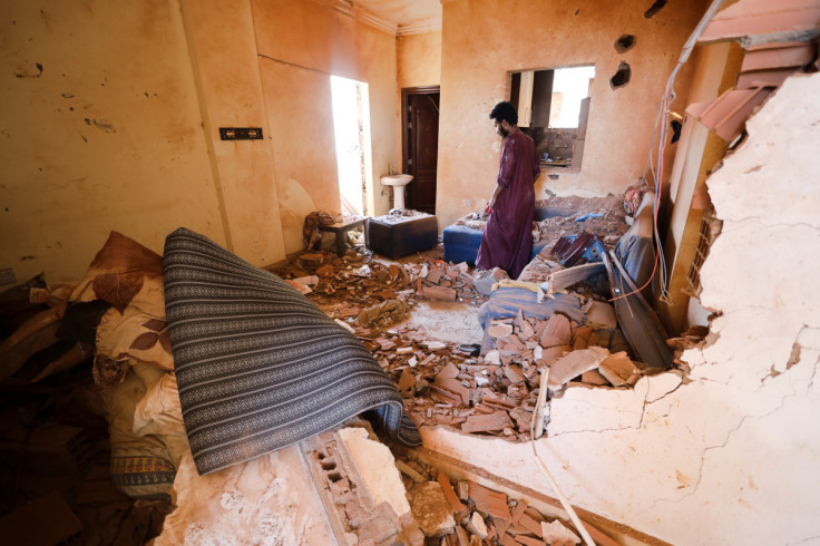 A man looks at belongings inside a damaged house during clashes between the paramilitary Rapid Support Forces and the army in Khartoum