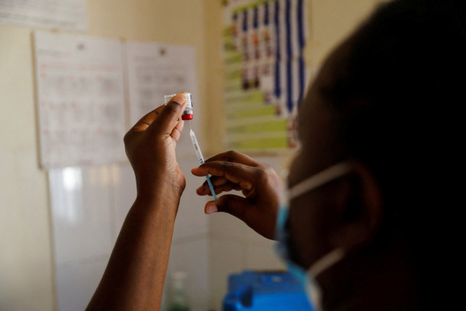 A nurse fills a syringe with malaria vaccine before administering it to an infant at the Lumumba hospital in Kisumu