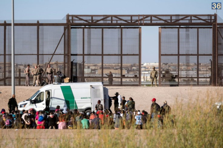 Migrants are processed by United States border patrol agents, seen from the Mexican side of the US-Mexico border in Ciudad Juarez