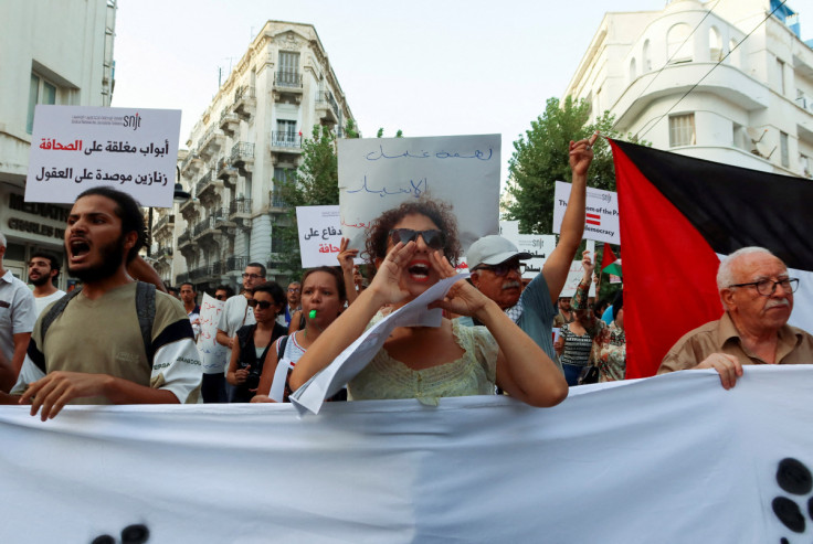Demonstrators carry banners during a protest calling for the freedom of expression in Tunis