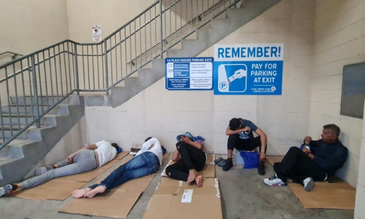 A group of migrants, the majority coming from Venezuela, attempt to rest in a parking garage after being released by Customs and Border Protection agents in Brownsville, Texas