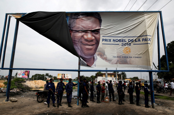 Congolese police officers stand under a banner for 2018 Nobel Peace Prize Denis Mukwege after a political rally of Martin Fayulu, the runner-up in Democratic Republic of Congo's presidential election in Kinshasa