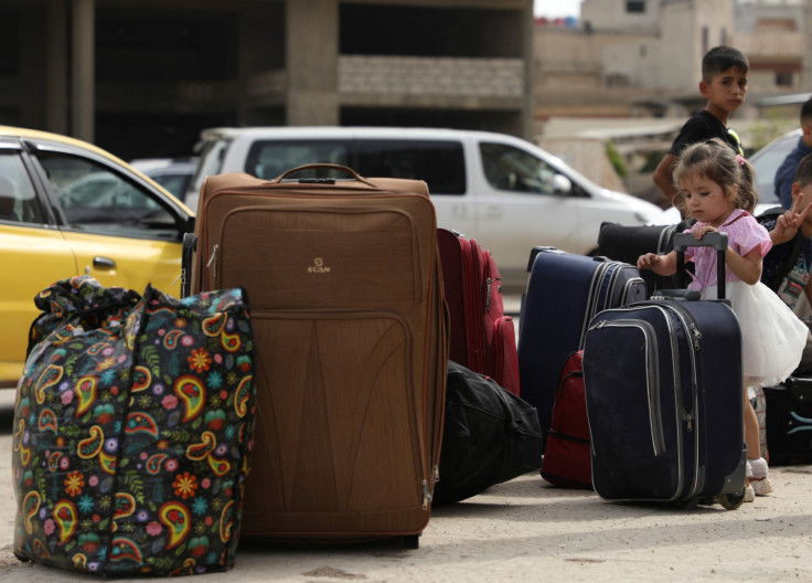 A Syrian Kurdish girl stands next to belongings after she was evacuated from Sudan, in Kurdish-controlled city of Qamishli