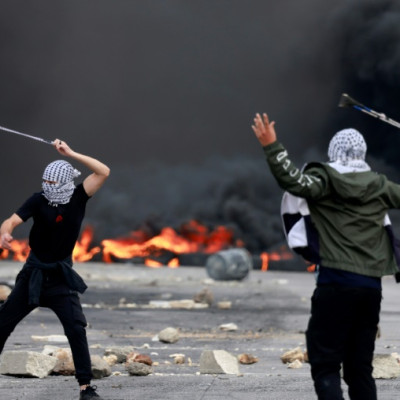 Palestinians in Ramallah on the West Bank hurl stones at Israeli forces during a demonstration against Israli bombardment of the Gaza Strip in retaliation for Hamas attacks