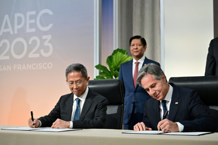 US Secretary of State Antony Blinken (R) and Philippines Secretary of Energy Raphael Lotilla sign a nuclear energy cooperation agreement in San Francisco, as Philippine President Ferdinand Marcos looks on
