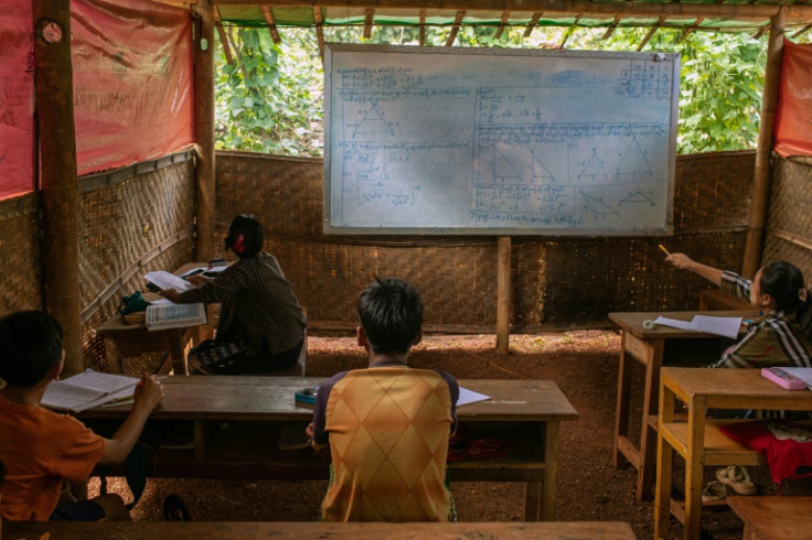 Children attend class in a temporary shelter at a camp for internally displaced people in Kayah