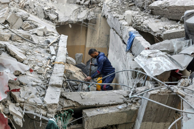 A Palestinian man cleans debris following Israeli bombardment in Rafah, the southern Gaza Strip