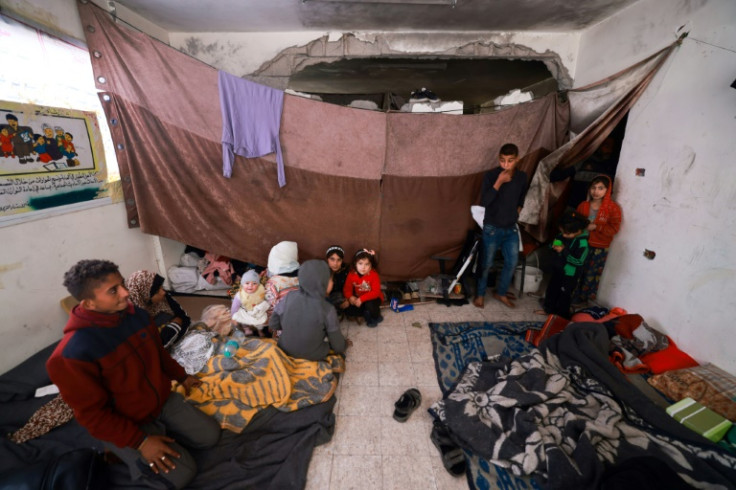 Displaced Palestinians take shelter inside a building damaged during Israeli bombardment in Rafah