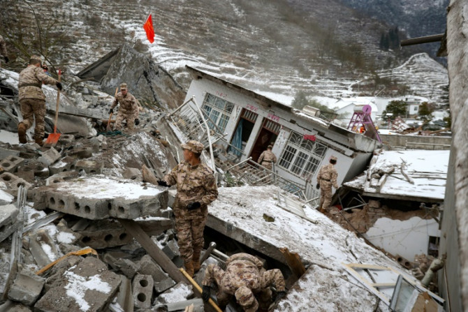 Chinese military personnel search for missing victims following a landslide in in southwestern China