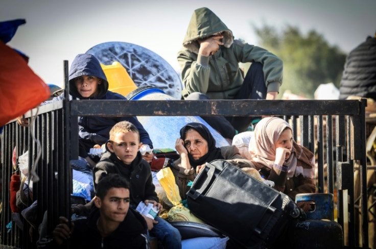 Palestinians flee the city of Khan Yunis in Gaza on the coastal road leading to Rafah as combat between Israel and Hamas rages