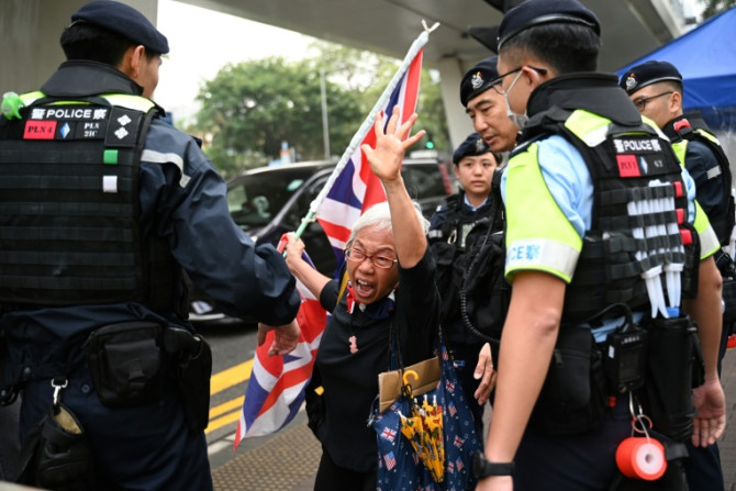 A pro-democracy protester known as "Grandma Wong" shouts slogans outside Hong Kong's West Kowloon court, where four men were convicted of rioting on Thursday
