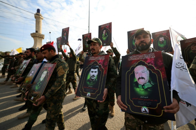 Members of Iraq's Hashed al-Shaabi (Popular Mobilization) paramilitary forces carry portraits on February 4, 2024 showing people killed the previous day in US strikes in western Iraq
