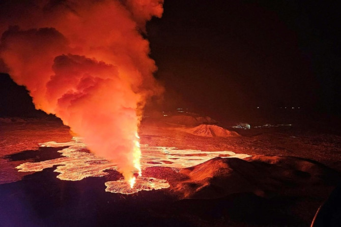 Live video images showed glowing lava oozing out of a fissure illuminating a plume of smoke rising up under the night sky