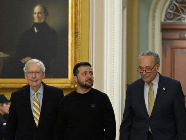 Ukrainian President Volodymyr Zelensky (C), accompanied by US Senate Majority Leader Chuck Schumer (R) and Minority Leader Mitch McConnell (L), arrives to meet with members of the US Senate on Capitol Hill in Washington, DC, on December 12, 2023.