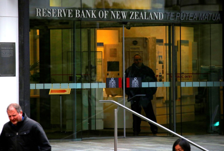 Pedestrians walk past as a security guard stands in the main entrance to the Reserve Bank of New Zealand located in central Wellington, New Zealand, July 3, 2017. 