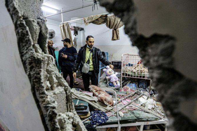 People inspect damage to a room following Israeli bombardment at Nasser hospital in Khan Yunis on December 17, 2023