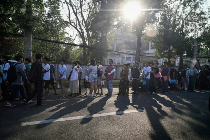 People stand in line to get visas at the Thai embassy in Yangon after Myanmar's military government said it would impose military service