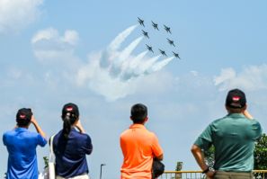 Spectators watch members of South Korea's 'Black Eagle' aerobatics team performing during a preview of the Singapore Airshow in Singapore on February 18, 2024