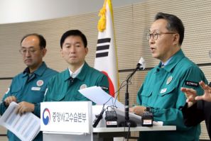 South Korea's Second Vice Health Minister Park Min-soo (R) speaks to reporters about a walkout by thousands of the country's trainee doctors