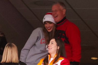 Scott Swift (top R), seen taking in an American football game with daughter Taylor Swift (L), is accused of punching a photographer