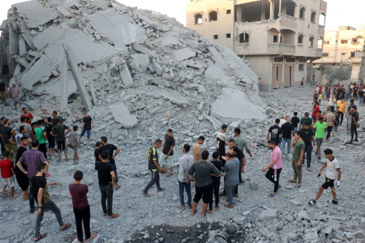 Palestinians check the remains of a building shortly after Israeli bombing levelled it in Nuseirat refugee camp, central Gaza