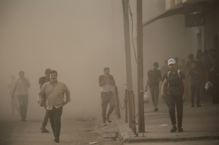Palestinians engulfed by dust and smoke after Israeli forces targeted a building in central Gaza