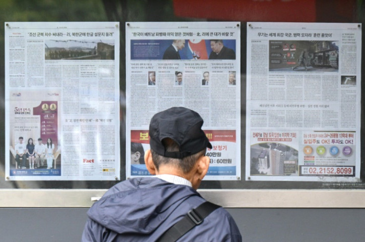 A man walks past a newspaper displayed on a street in Seoul on October 21 with coverage on North Korea's decision to deploy thousands of soldiers to Russia