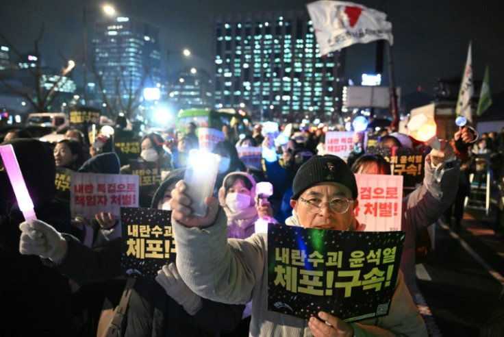 Protesters wave light sticks with placards reading 'Arrest Insurrectionist Yoon Suk Yeol!' during a rally calling for the ouster of the South Korean president