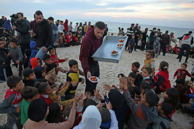 Hamada Shaqura, a former food blogger, distributes food after cooking a meal for displaced Palestinians in Khan Yunis, southern Gaza